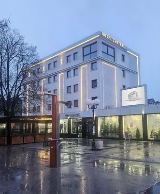 a building on a rainy street in front at Hotel Central in Inđija