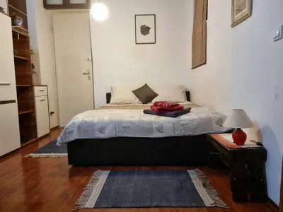 a bedroom with a bed and a table with a lamp at Belgrade center studio apartment in Belgrade