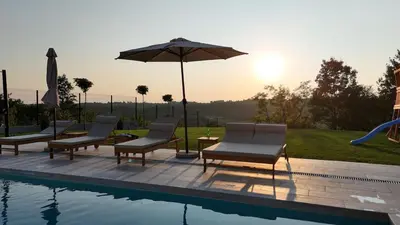 a group of chairs and an umbrella next to a pool at Casa Toleni in Ba°evac