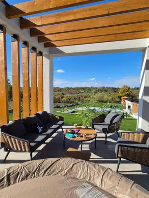 a patio with a couch and chairs and a table at Casa Toleni in Ba°evac