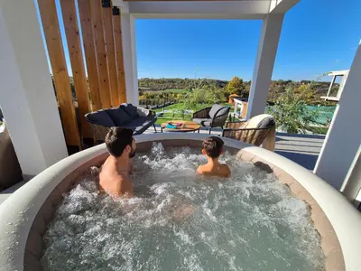 two people in a hot tub on a patio at Casa Toleni in Ba°evac
