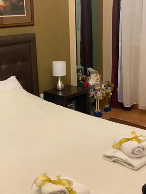 a bedroom with a bed with towels and a mirror at Verdi Apartment in Belgrade