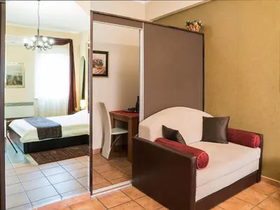 a room with a mirror and a bed and a chair at Verdi Apartment in Belgrade