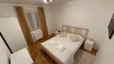 a small bedroom with a white bed with two pillows at GardosHouse Apt 2 in Belgrade