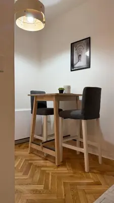 a dining room table with two chairs and a lamp at GardosHouse Apt 3 in Belgrade