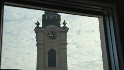 a clock tower is seen through a window at GardosHouse Apt 4 in Belgrade