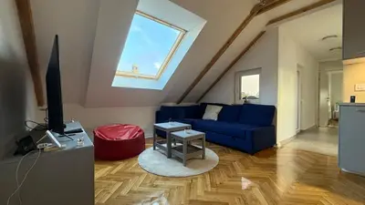 a living room with a blue couch and a window at GardosHouse Apt 4 in Belgrade