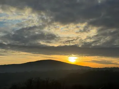 a sunset over a mountain with the sun setting at KosMy dream in Sopot
