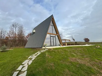 a house on a grassy hill with a building at KosMy dream in Sopot