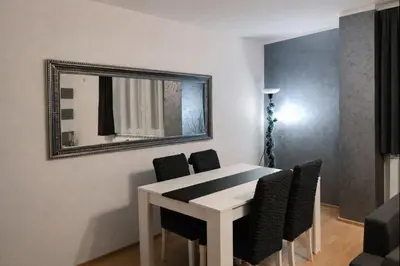 a white dining room table with chairs and a mirror at Apartman LAV in Belgrade