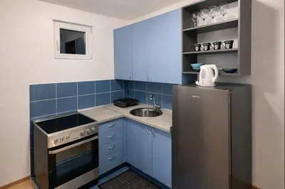 a blue kitchen with a sink and a refrigerator at Apartman LAV in Belgrade