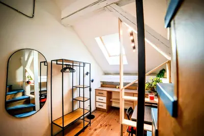 a small attic bedroom with a mirror and a desk at Old Port Riverside Lofts in City Center in Belgrade
