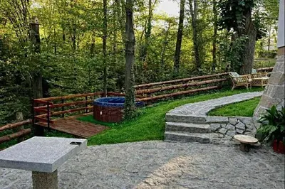a park with a wooden fence and a bench at Šumarak Weekend House in Arandjelovac