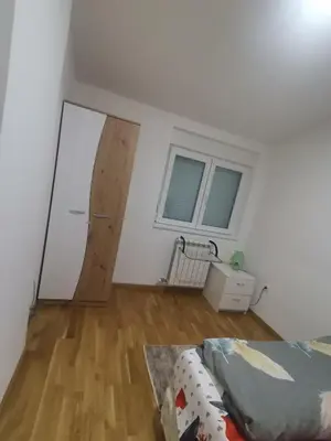 a room with a bed and a wooden floor at Stan na dan Lux Stara Pazova in Stara Pazova