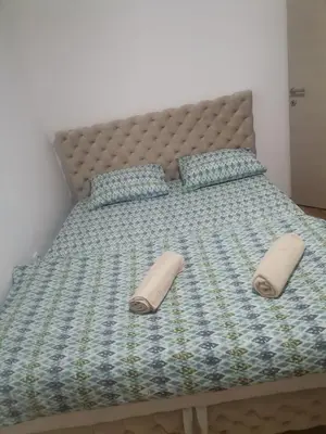 a bed with two pillows on top of it at Stan na dan Lux Stara Pazova in Stara Pazova