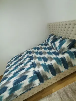 a bed with a blue and white blanket on it at Stan na dan Lux Stara Pazova in Stara Pazova