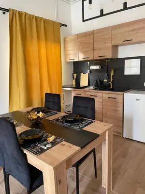 a kitchen with a table and chairs and a kitchen with a refrigerator at Dolce Vita in Belgrade