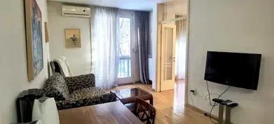 a living room with a couch and a tv at One Bedroom Apartment Theatre in Belgrade