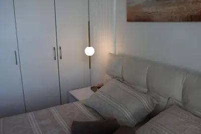 a bedroom with a bed with a white headboard and a lamp at Belgrade Waterfront Quartet 3 in Belgrade