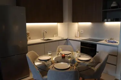 a kitchen with a table and chairs with wine glasses at Belgrade Waterfront Quartet 3 in Belgrade