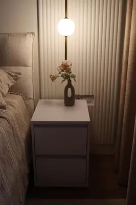 a table with a vase with flowers on it next to a bed at Belgrade Waterfront Quartet 3 in Belgrade