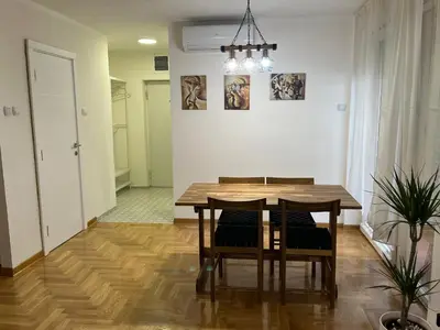 a dining room with a wooden table and chairs at Mila in Belgrade