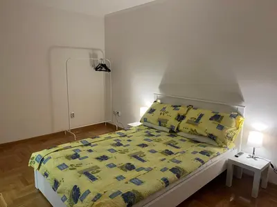 a bedroom with a bed with a yellow comforter at Mila in Belgrade