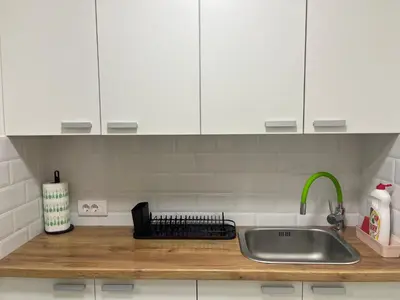 a kitchen counter with a sink and white cabinets at Mila in Belgrade
