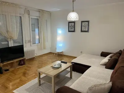 a living room with a couch and a tv and a table at Mila in Belgrade