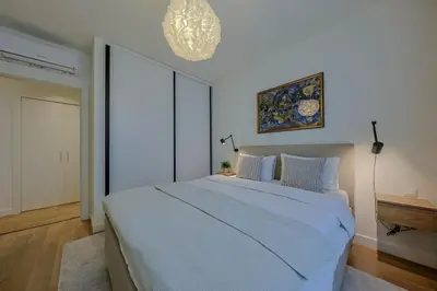a bedroom with a large white bed with a chandelier at S310 with free parking in Belgrade