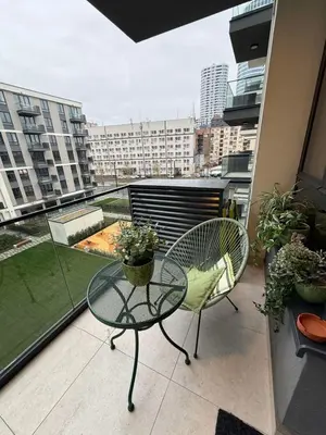 a balcony with a table and chairs on a balcony at S310 with free parking in Belgrade