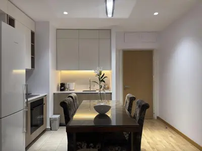 a kitchen with a wooden table with chairs around it at Beograd na vodi Belgrade waterfront - 23th floor, great view apartment in Belgrade