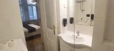 a white bathroom with a sink and a mirror at Central Apartment Toplica in Belgrade