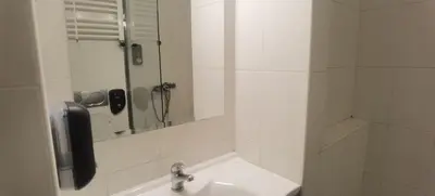 a white bathroom with a sink and a mirror at Central Apartment Toplica in Belgrade