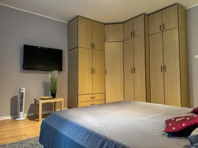 a bedroom with wooden cabinets and a large bed at Vista Dorćol - Old Town - Heart of Belgrade in Belgrade