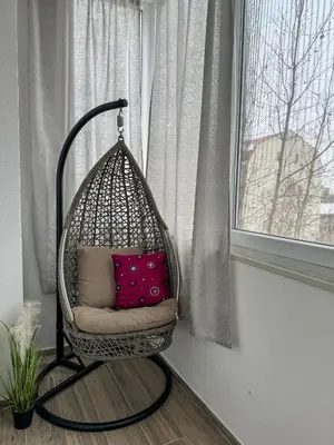 a hanging basket chair with two pillows in a window at Vista Dorćol - Old Town - Heart of Belgrade in Belgrade