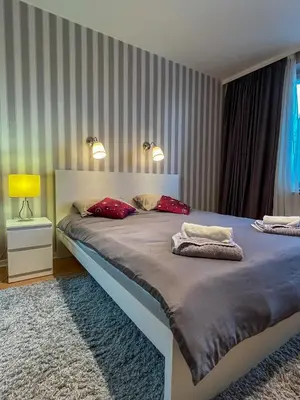 a bedroom with a large bed with red pillows at Vista Dorćol - Old Town - Heart of Belgrade in Belgrade
