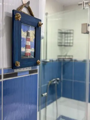a blue bathroom with a picture of a lighthouse at Vista Dorćol - Old Town - Heart of Belgrade in Belgrade