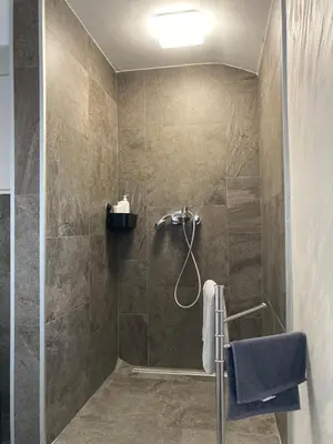 a bathroom with a shower with a glass door at Vranjes apartman in Beograd