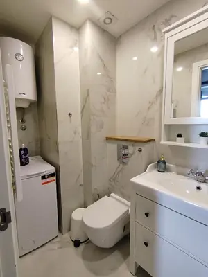 a white bathroom with a toilet and a sink at Benvenuti SUN in Belgrade
