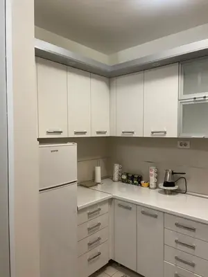 a kitchen with white cabinets and a white refrigerator at Nika Apartments Vracar in Belgrade