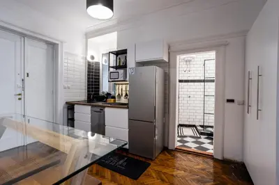 a kitchen with a refrigerator and a glass table at City Center Suites, Two Connected Apartments, 10 Guests in Belgrade