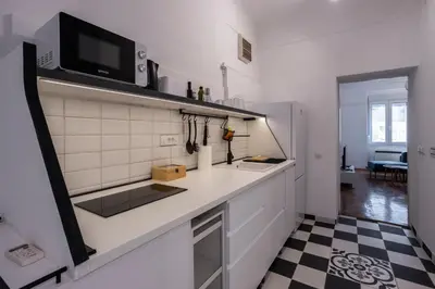 a kitchen with a white counter and a black and white floor at City Center Suites, Two Connected Apartments, 10 Guests in Belgrade