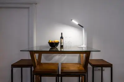 a table with a bottle of wine and a bowl of fruit at City Center Suites, Two Connected Apartments, 10 Guests in Belgrade