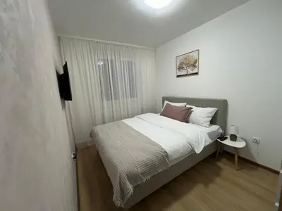 a small bedroom with a bed and a window at Gold Star Apartman in Ruma