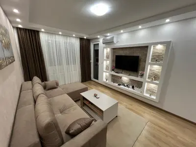 a living room with a couch and a tv at Gold Star Apartman in Ruma