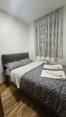a bedroom with a bed and a window at Apartman Simić in Smederevo
