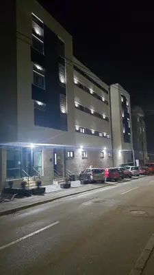 a large building with cars parked in front of it at Apartman Simić in Smederevo