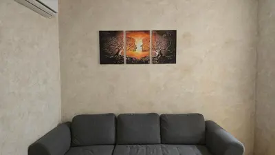 a living room with a couch and a painting on the wall at Apartman Simić in Smederevo