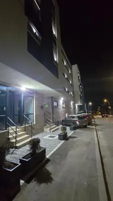 a parking lot in front of a building at night at Apartman Simić in Smederevo